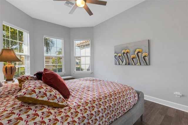 bedroom with a ceiling fan, visible vents, baseboards, and dark wood-type flooring