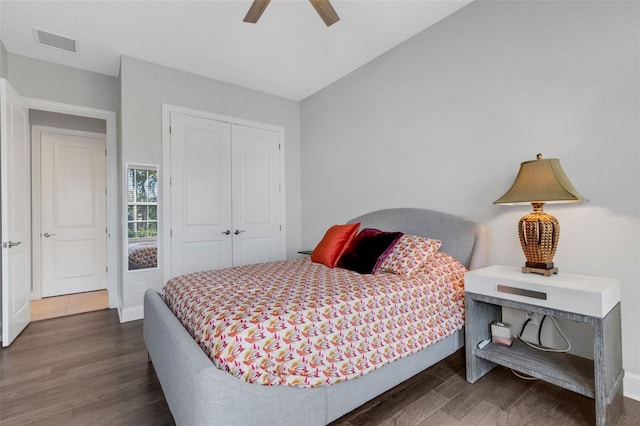 bedroom with vaulted ceiling, a closet, wood finished floors, and visible vents