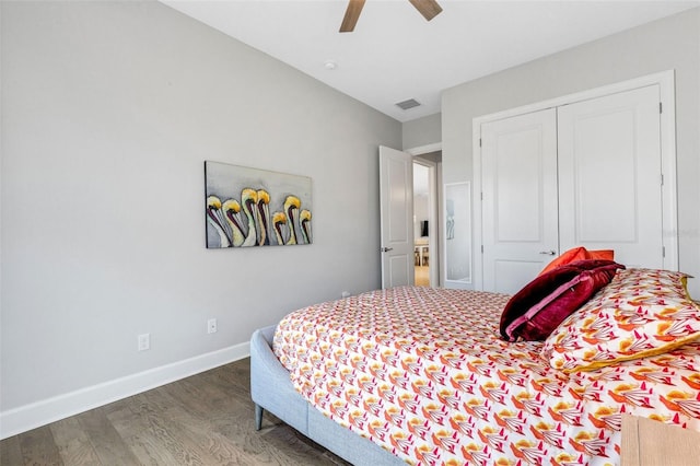 bedroom with baseboards, visible vents, a ceiling fan, wood finished floors, and a closet