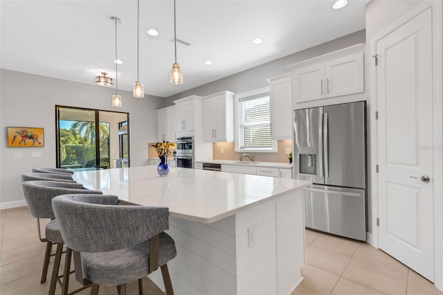 kitchen with visible vents, white cabinets, stainless steel appliances, light countertops, and a sink