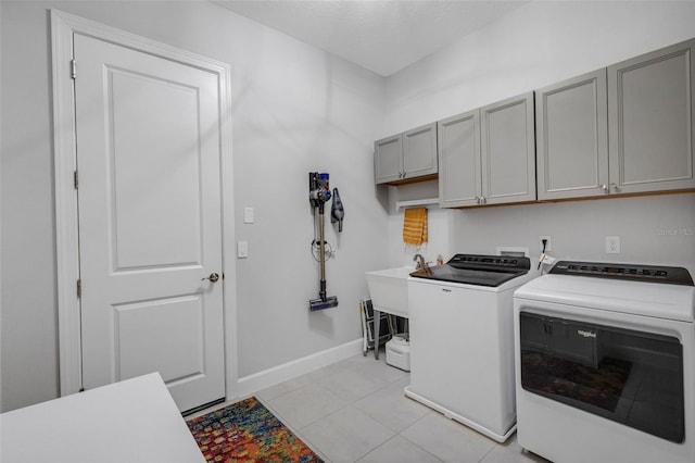 washroom featuring separate washer and dryer, light tile patterned flooring, cabinet space, and baseboards