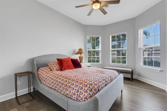 bedroom featuring a ceiling fan, wood finished floors, visible vents, and baseboards