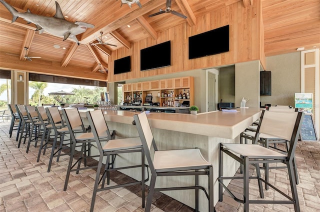 kitchen with a ceiling fan, wood ceiling, high vaulted ceiling, and beam ceiling