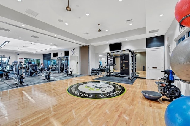 exercise room featuring a tray ceiling and visible vents