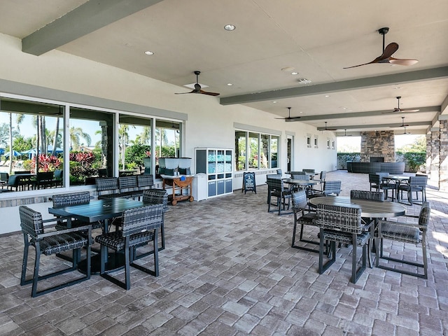 view of patio with outdoor dining area, visible vents, and ceiling fan