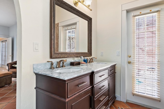 bathroom with tile patterned floors, vanity, and a healthy amount of sunlight