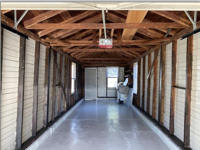 garage with wooden walls and a garage door opener