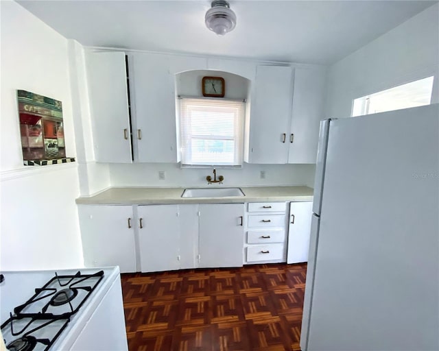 kitchen with white cabinetry, sink, a healthy amount of sunlight, and white appliances