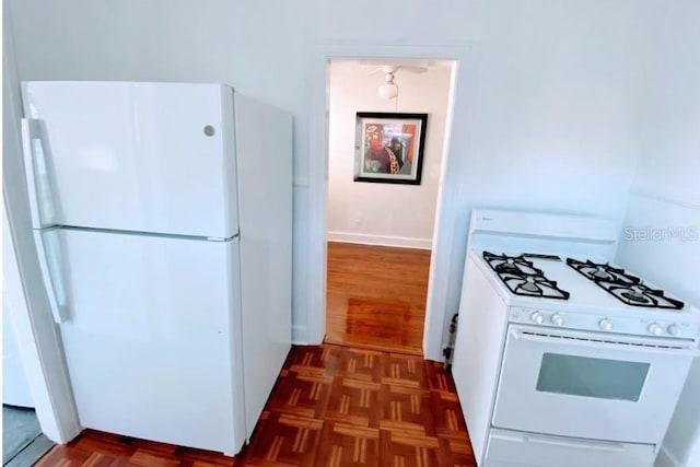 kitchen featuring dark parquet flooring and white appliances