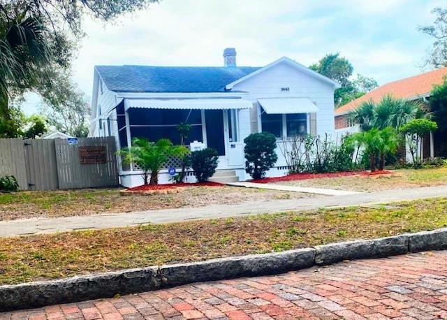 bungalow-style house featuring crawl space, fence, and a chimney