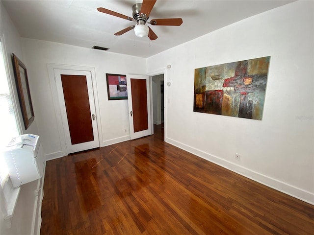 unfurnished bedroom featuring ceiling fan, wood-type flooring, visible vents, and baseboards