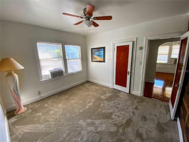 unfurnished bedroom featuring cooling unit, carpet flooring, a ceiling fan, and baseboards