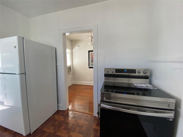 kitchen with parquet floors, stainless steel range with electric cooktop, and freestanding refrigerator