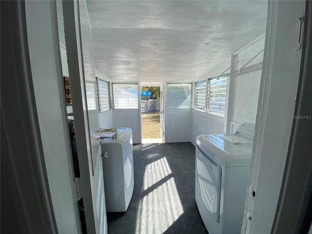 washroom with laundry area, washing machine and dryer, and dark colored carpet