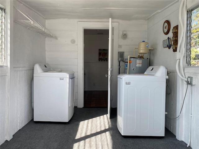 clothes washing area featuring laundry area, water heater, and independent washer and dryer