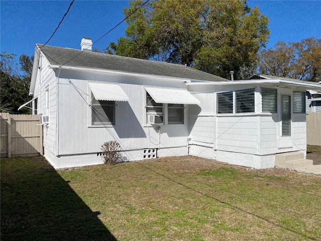 rear view of house featuring a lawn, a chimney, crawl space, fence, and cooling unit