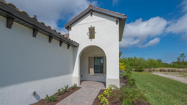 doorway to property with a lawn