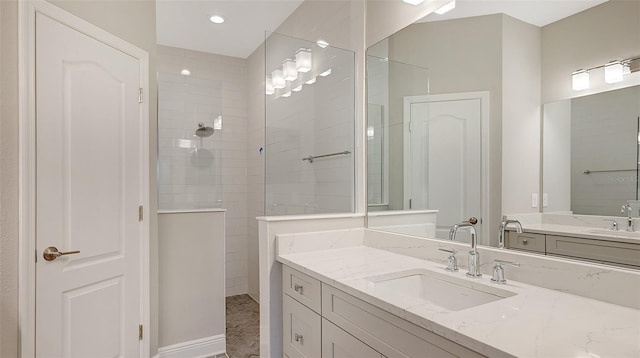 bathroom with tiled shower and vanity