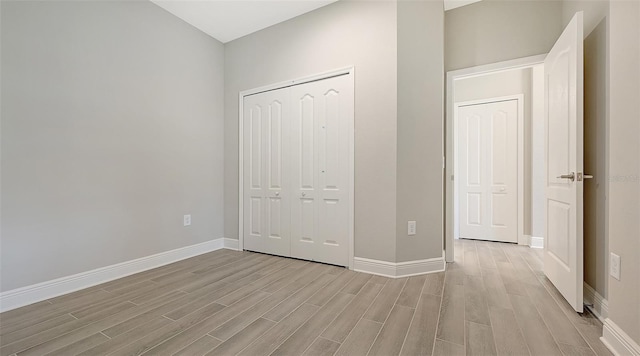 unfurnished bedroom with a closet and light hardwood / wood-style flooring