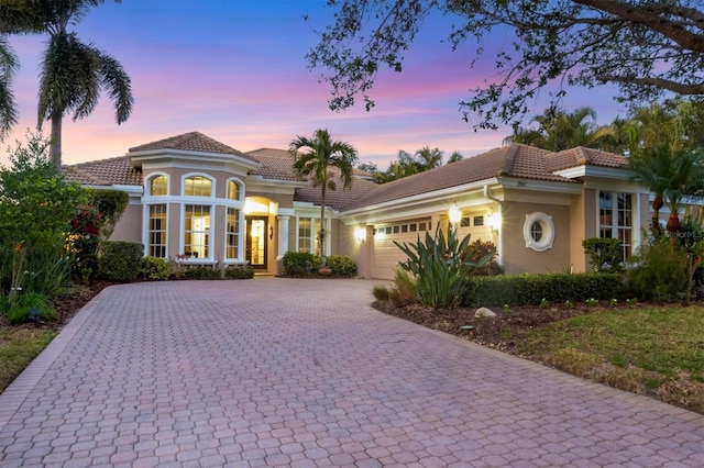 mediterranean / spanish-style house with a garage and french doors