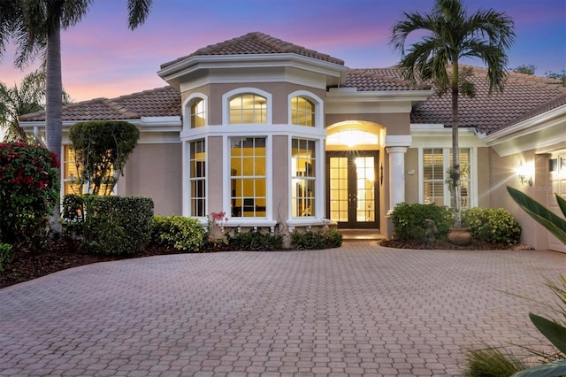 back house at dusk featuring french doors