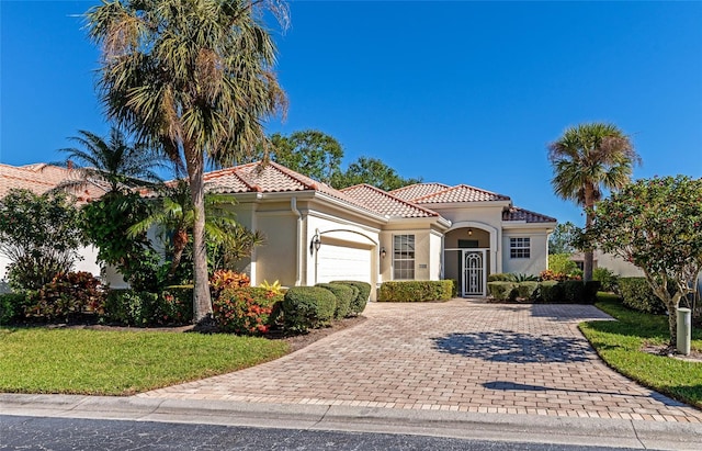 mediterranean / spanish house with a front yard and a garage