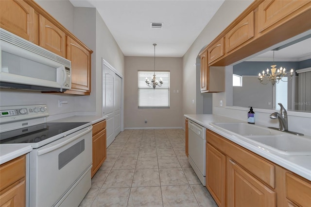 kitchen with white appliances, sink, light brown cabinets, decorative light fixtures, and a chandelier