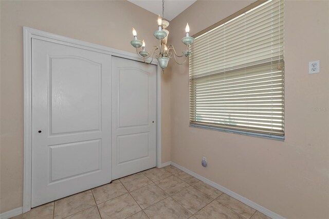 interior space featuring light tile patterned floors and a chandelier