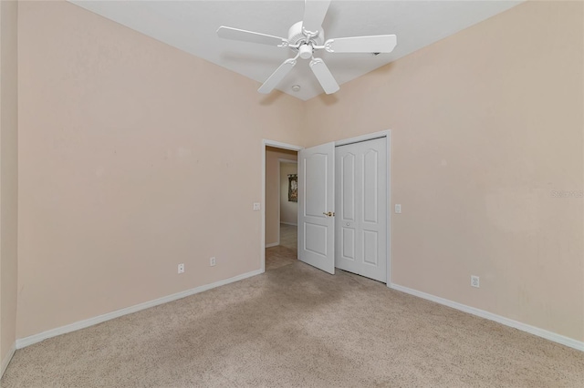 spare room with ceiling fan and light colored carpet