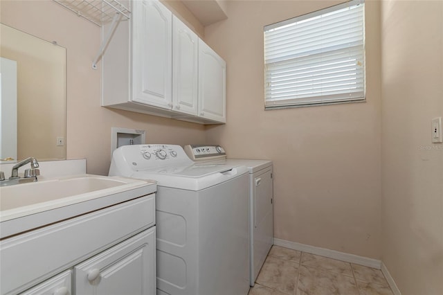 laundry area featuring cabinets, light tile patterned floors, and washing machine and clothes dryer