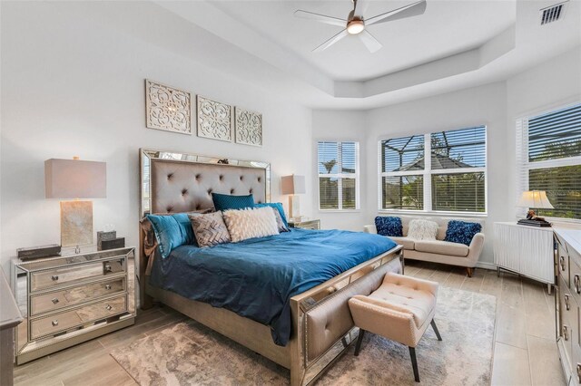 bedroom featuring multiple windows, light hardwood / wood-style flooring, and ceiling fan