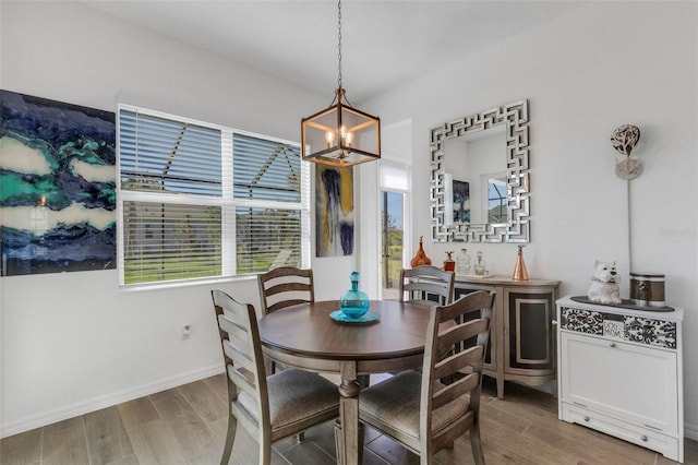 dining room with wood-type flooring and a notable chandelier