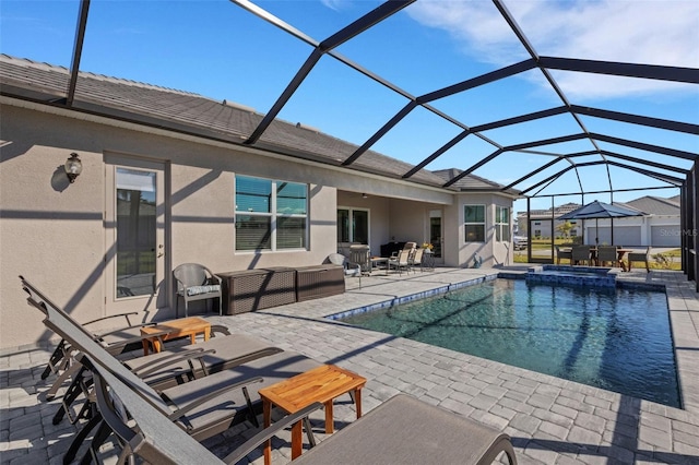 view of pool featuring glass enclosure, an in ground hot tub, and a patio