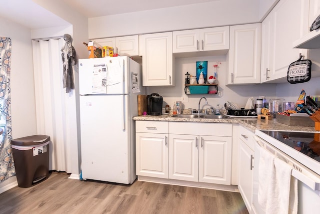 kitchen featuring white appliances, white cabinetry, light hardwood / wood-style flooring, and sink