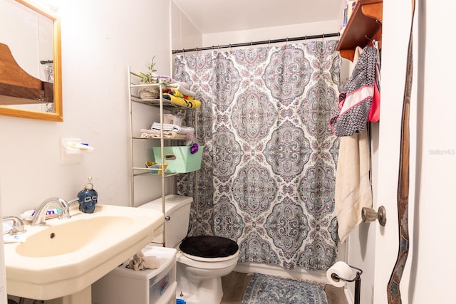 bathroom with toilet, curtained shower, and sink