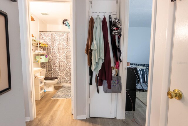 1038 25th St, Sarasota, FL 34234 - bathroom with wood finished floors, a spacious closet, a shower with curtain, and vanity