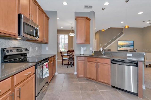 kitchen featuring sink, decorative light fixtures, decorative backsplash, light tile patterned floors, and appliances with stainless steel finishes