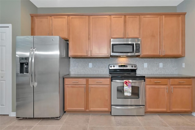 kitchen with backsplash, light tile patterned flooring, and stainless steel appliances