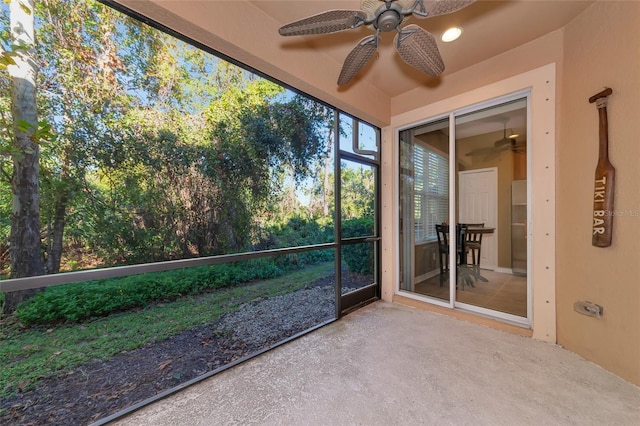 unfurnished sunroom featuring ceiling fan