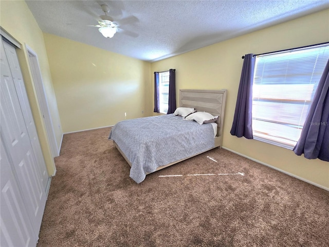 carpeted bedroom with multiple windows, ceiling fan, and a textured ceiling