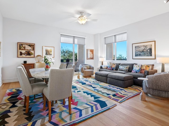 living room featuring light hardwood / wood-style flooring, a wealth of natural light, and ceiling fan