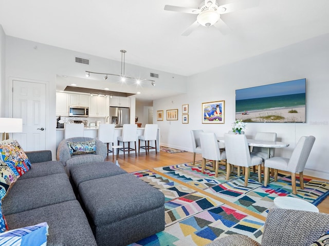 living room with ceiling fan and light wood-type flooring