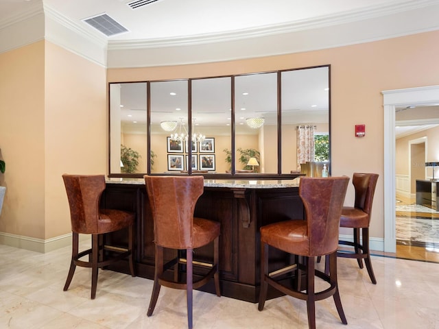 bar with an inviting chandelier and ornamental molding