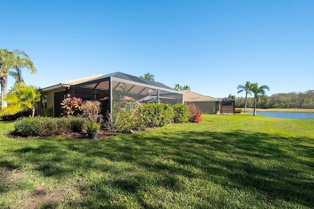 view of yard with a lanai and a water view