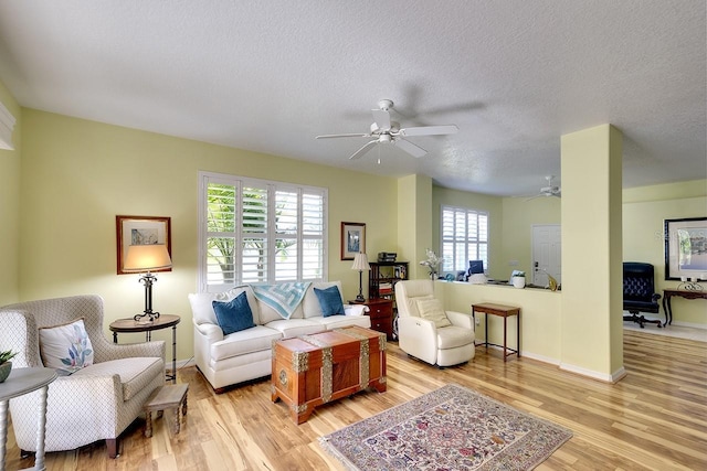 living room with a healthy amount of sunlight, a textured ceiling, and light hardwood / wood-style flooring