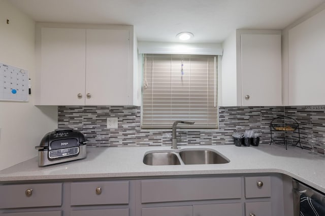 kitchen featuring gray cabinetry, decorative backsplash, and sink