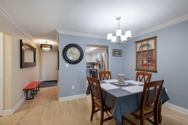 dining room featuring light hardwood / wood-style floors, crown molding, and a chandelier