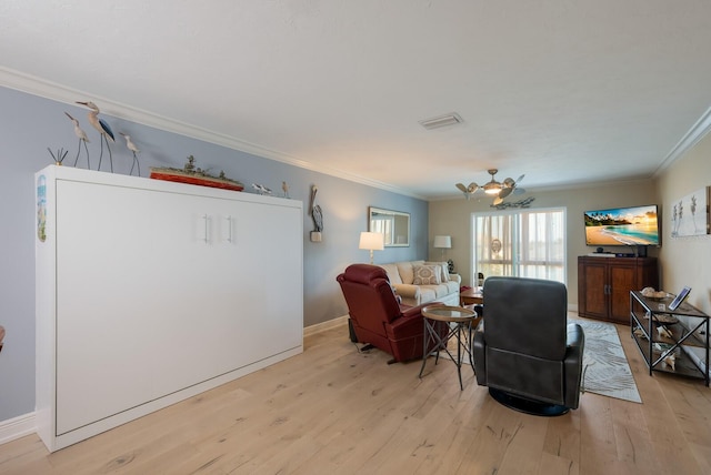 living room with crown molding, light hardwood / wood-style flooring, and ceiling fan