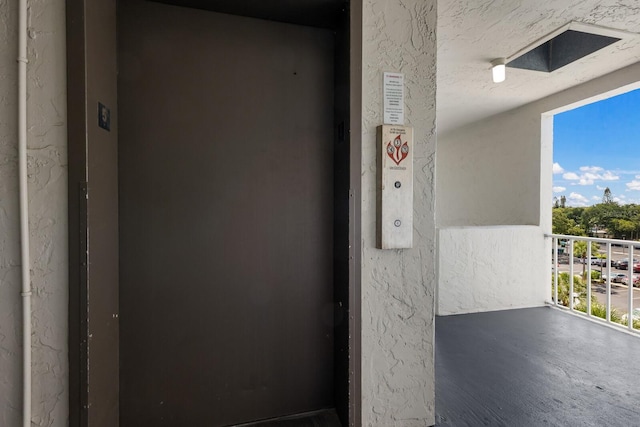 doorway to property featuring elevator and a balcony