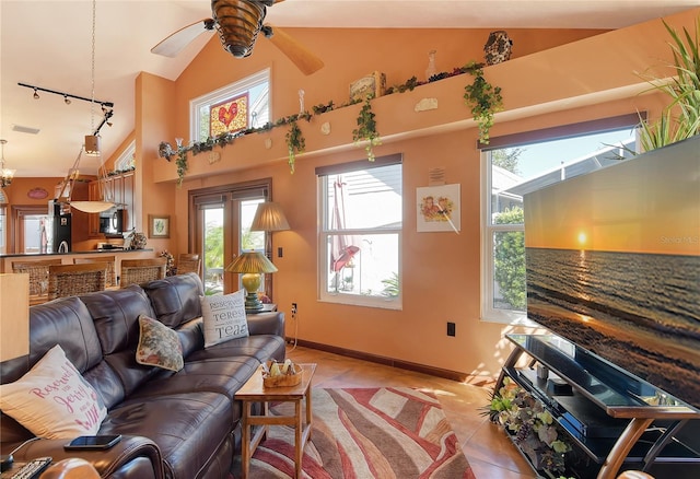 tiled living room with plenty of natural light, ceiling fan, and high vaulted ceiling